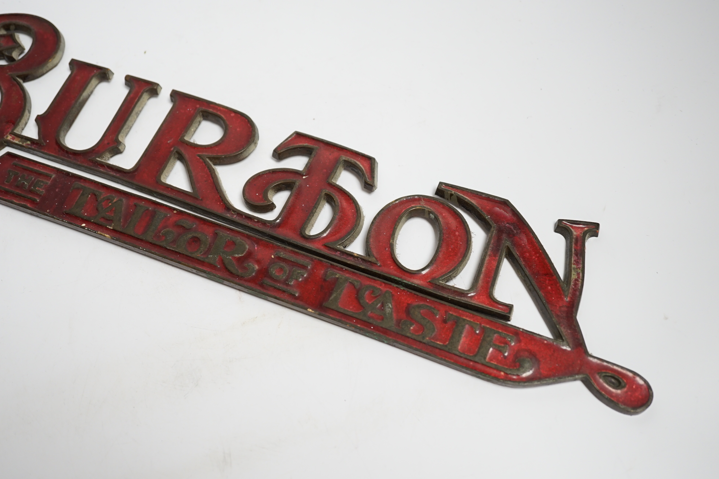 An enamelled bronze 'Montague Burton The Tailor of Taste' shop sign, 41cm wide